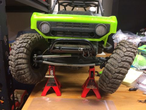 1989 Ford Bronco - This RC rock crawler is elevated on red jack stands, showing off its suspension and large off-road tires.