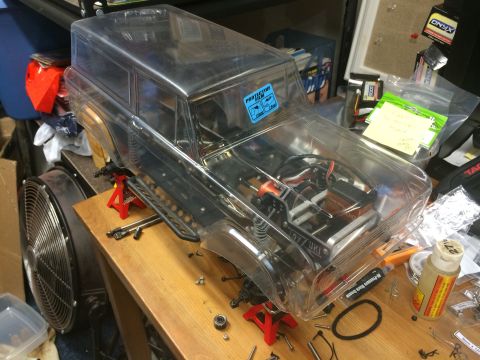 1989 Ford Bronco - RC car body shell, likely a Bronco, is disassembled and placed on jack stands for maintenance.