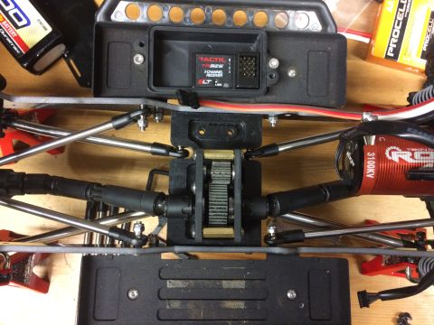 1989 Ford Bronco - Close-up of an RC car's chassis, detailing the motor, receiver, and drivetrain parts.