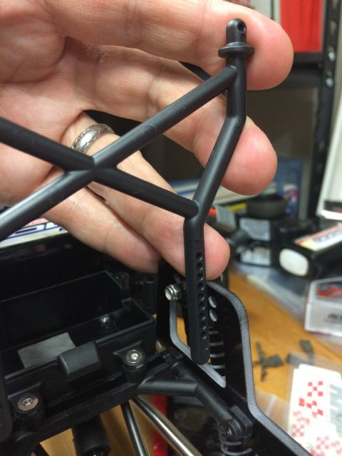 1989 Ford Bronco - Close-up of a black plastic roll cage part being held for an RC car build.
