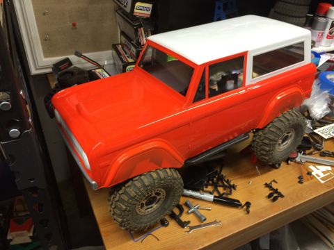 1989 Ford Bronco - An unpainted RC car body, resembling a classic SUV, sits on a cluttered workbench.