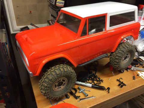 1989 Ford Bronco - This is a model RC car body, possibly a Ford Bronco, sitting on a workbench with various tools and parts scattered around.