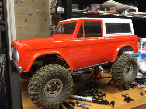 1989 Ford Bronco - RC model of a classic Ford Bronco, likely a 1978 model, sits on jack stands with parts scattered around.