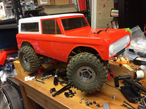 1989 Ford Bronco - RC car body on a workbench, surrounded by tools and spare parts.
