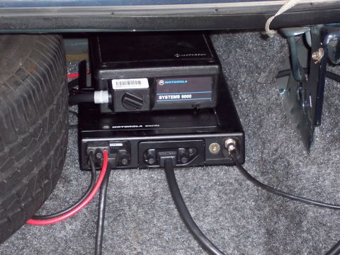 2001 Ford Crown Victoria - Motorola radio equipment and a spare tire are visible in the trunk of a vehicle.