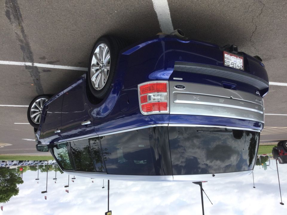 Rear passenger side of a dark blue SUV with silver trim and Ford XLT badging.