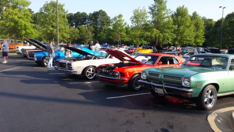 1976 Ford Ranchero - Several classic cars are parked in a lot with their hoods open, suggesting a car show or meet.