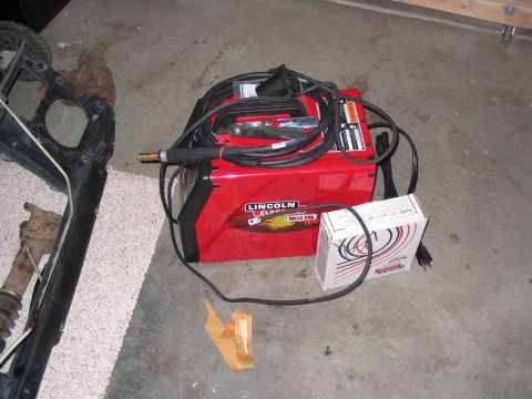 1996 Ford Bronco - A red Lincoln Electric Weld Pak 100 welder and associated supplies are shown on a garage floor.