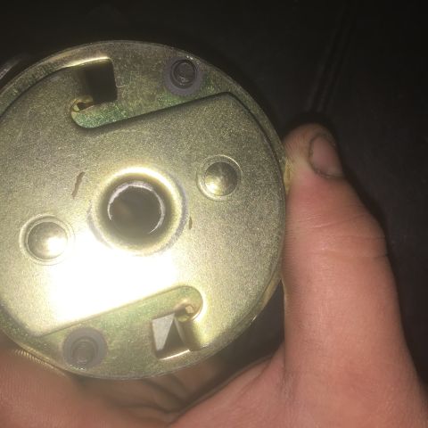 1971 Dodge Dart - A close-up view of a gold-colored metal component, possibly a mechanical part, held in a hand.