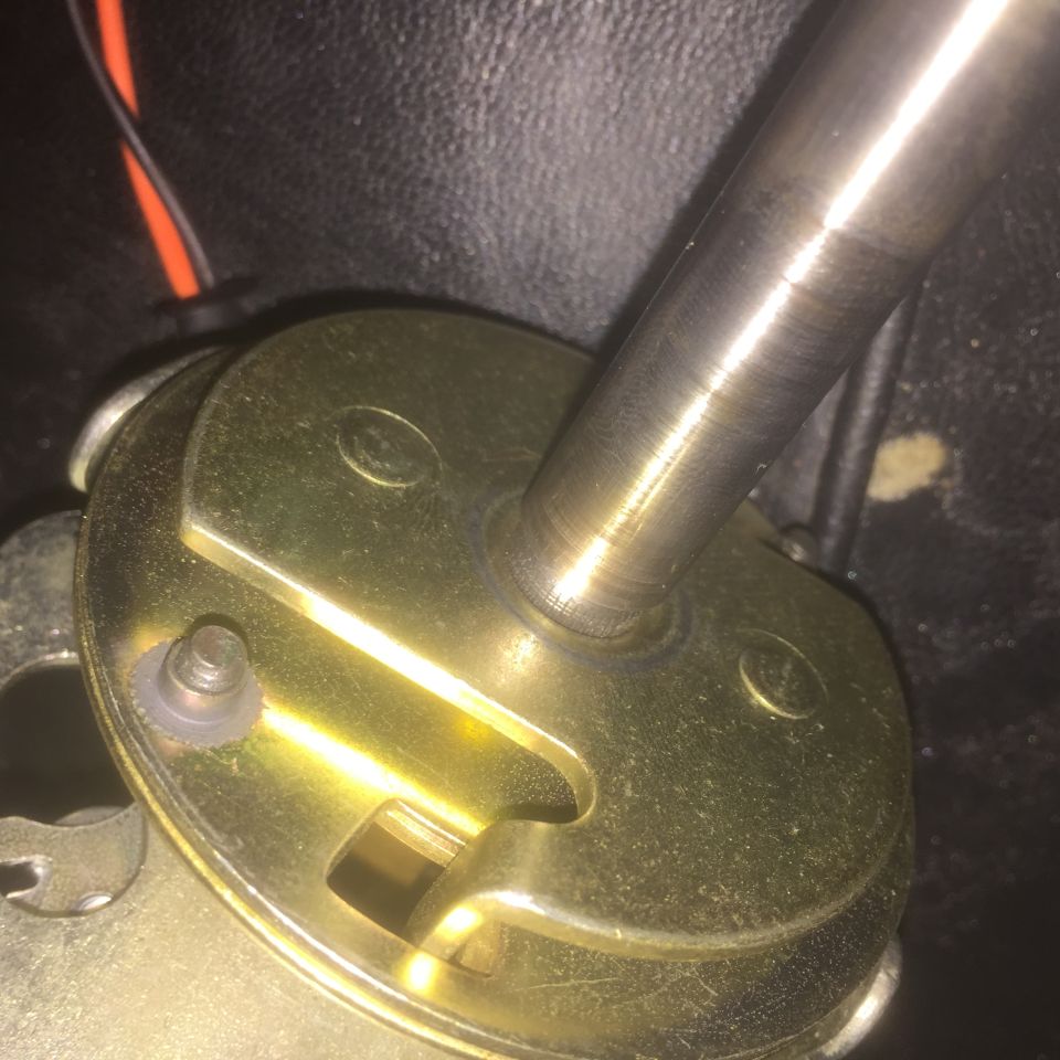 Close-up of a brass gear shifter mechanism with a metal lever and visible wiring