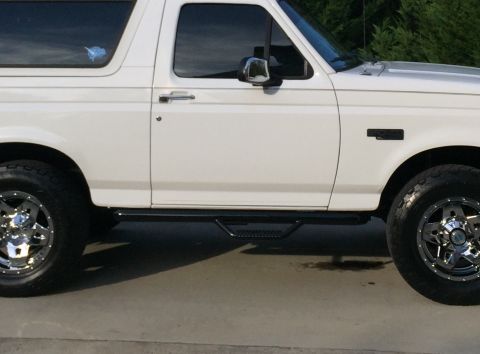 2014 Dodge 1500 - Side view of a white SUV, aftermarket side steps and chrome wheels.