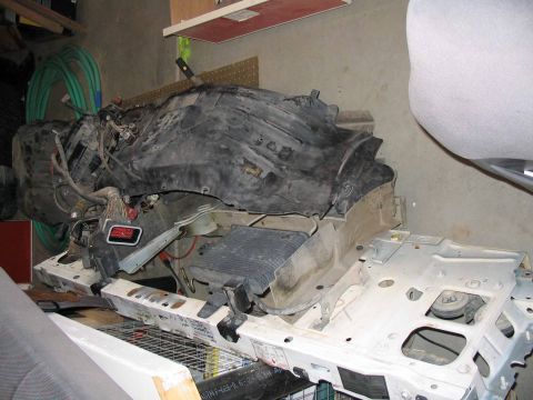 1996 Ford Bronco - Disassembled vehicle parts, including a radiator and black plastic shroud, are piled up.