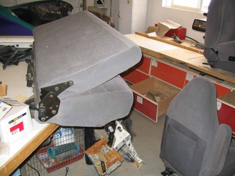 1996 Ford Bronco - Disassembled vehicle seats are shown in a workshop setting with storage bins and tools in the background.