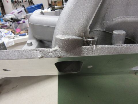 Close-up of an engine intake manifold with a Supermotors.net logo visible