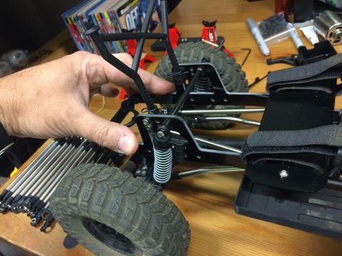 1989 Ford Bronco - Close-up of an RC car's chassis and suspension system during assembly or modification.