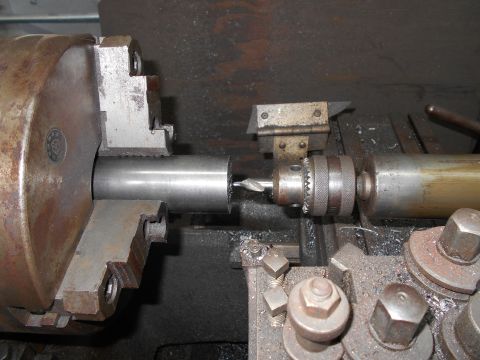 1992 Ford Bronco - A metal rod is being drilled on a lathe, with metal shavings visible around the machinery.