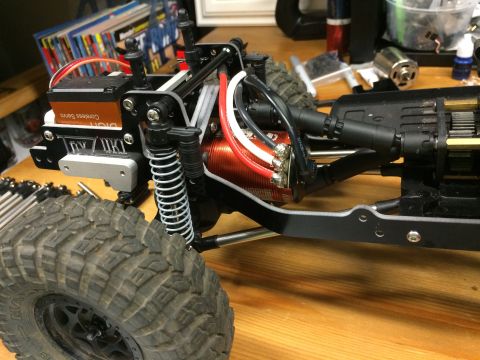 1989 Ford Bronco - Close-up of a remote control car's internal components, including the motor and servo, with a large tire visible.