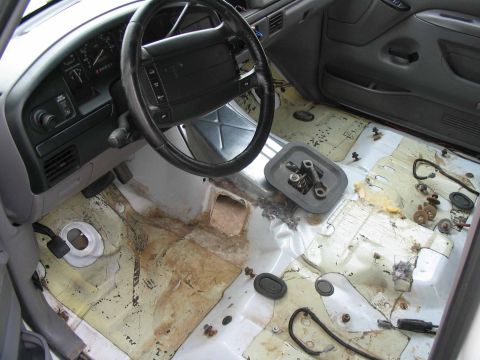 1996 Ford Bronco - The interior of a 1996 Ford Bronco shows its disassembled floor and dashboard, with the carpet removed for maintenance or after repairs.