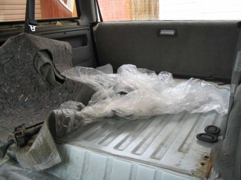 1996 Ford Bronco - Interior view of the cargo area of a 1996 Ford Bronco, covered with plastic sheeting.