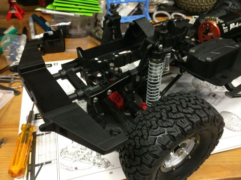 1989 Ford Bronco - The chassis of a remote-controlled car is shown, with a large tire and suspension components visible.