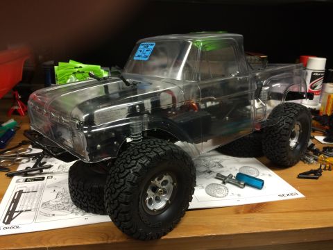 1989 Ford Bronco - RC car model with clear body on a workbench with assembly instructions.