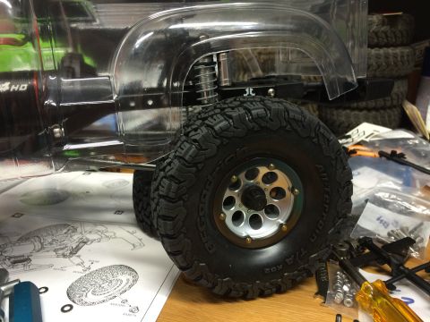 1989 Ford Bronco - RC car model parts and assembly instructions are spread across a workbench.