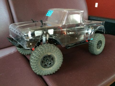 1989 Ford Bronco - This RC truck features a clear body and aggressive off-road tires, presented from a three-quarter front perspective.