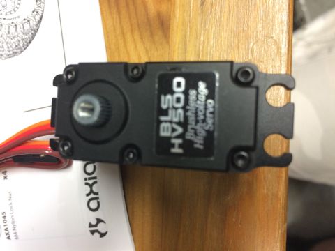 1989 Ford Bronco - A black BLS HV500 brushless high-voltage servo motor is shown, resting on a wooden surface next to some documentation.