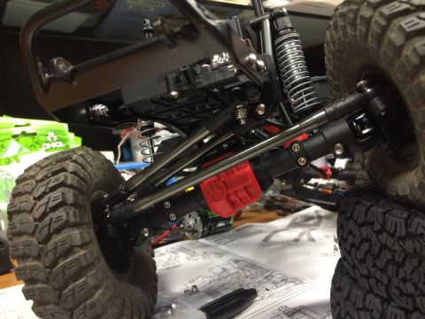 1989 Ford Bronco - Close-up of an RC car's suspension and drivetrain components, with assembly instructions visible below.
