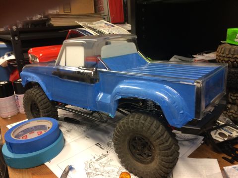1989 Ford Bronco - RC truck body being assembled on a workbench with tools and instructions.