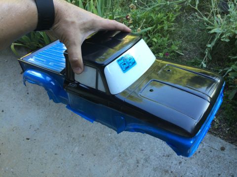 1989 Ford Bronco - A person holds a black and blue RC truck body, which appears to be a model of an older pickup truck.