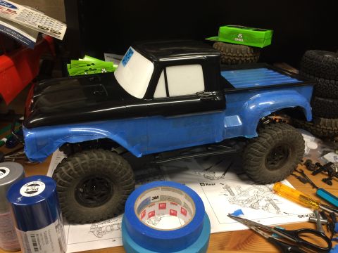 1989 Ford Bronco - RC truck body with blue masking tape, ready for paint. Tools and spare tires are visible.