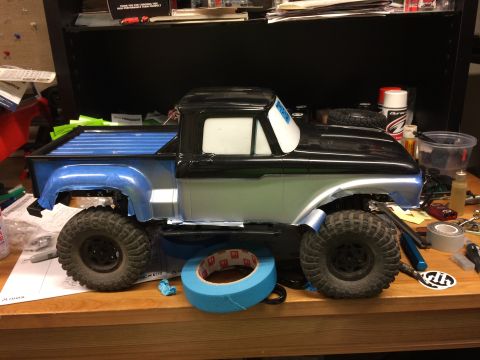 1989 Ford Bronco - RC truck body with blue bed sits on a workbench, surrounded by crafting supplies.