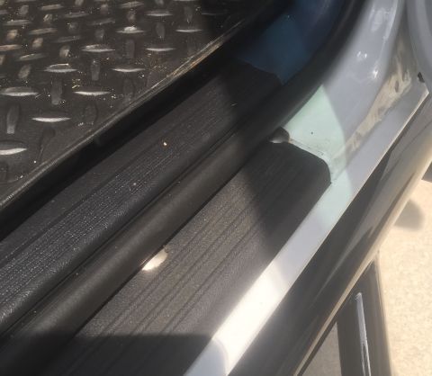 1995 Ford Bronco - Close-up of a vehicle's interior door sill and floor mat, showing textured surfaces and a watermark.