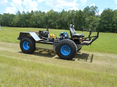 1992 Ford Bronco - This custom-built vehicle features large tires, an exposed engine, and a basic seating arrangement.