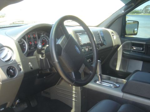 2005 Ford F-150 - The interior of a 2005 Ford F-150, its dashboard, steering wheel, and automatic transmission shifter.