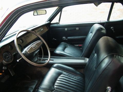 1968 Mercury Cougar - The interior of a 1968 Mercury Cougar shows black vinyl seats and a wood-grain dashboard.