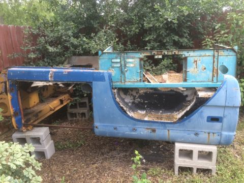 1979 Ford Bronco - Disassembled vehicle body sections, appearing to be from a truck or SUV, sit in an outdoor setting.