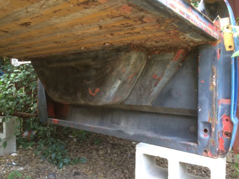 1979 Ford Bronco - The underside of a 1979 Ford Bronco bed reveals significant rust and the vehicle's structural components.