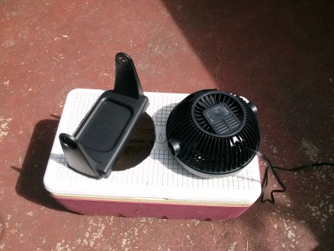 1996 Ford Bronco - A car air conditioner vent mount and a black fan are placed on a cooler.