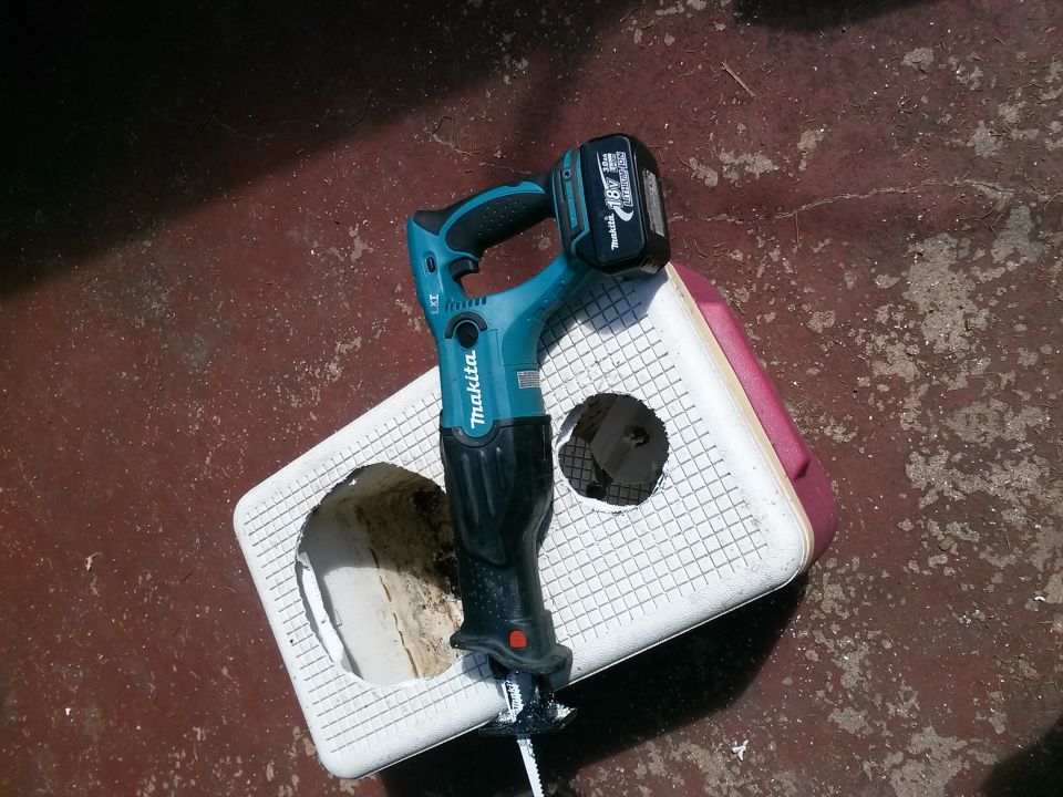 Reciprocating saw with 18V battery on a white plastic surface