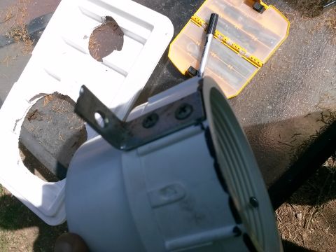 1996 Ford Bronco - A white housing for an air conditioner part is shown with a metal bracket attached.