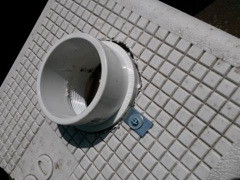 1996 Ford Bronco - A close-up view shows a PVC pipe fitting secured to a textured surface with a metal bracket.