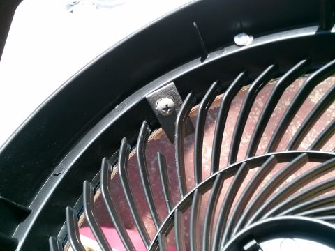 1996 Ford Bronco - Close-up of a black fan grille, showing a metal bracket and screw securing the housing.