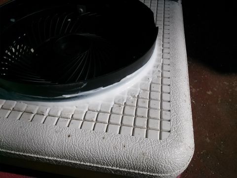1996 Ford Bronco - A black fan shroud is shown with white sealant applied to its base, resting on a tiled surface.