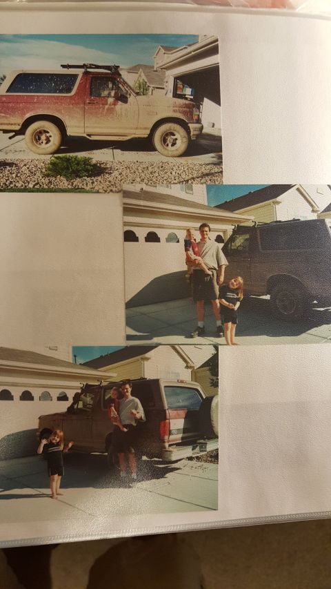1996 Ford Bronco - A dusty red and tan Ford Bronco is parked in a suburban driveway, equipped with a roof rack.
