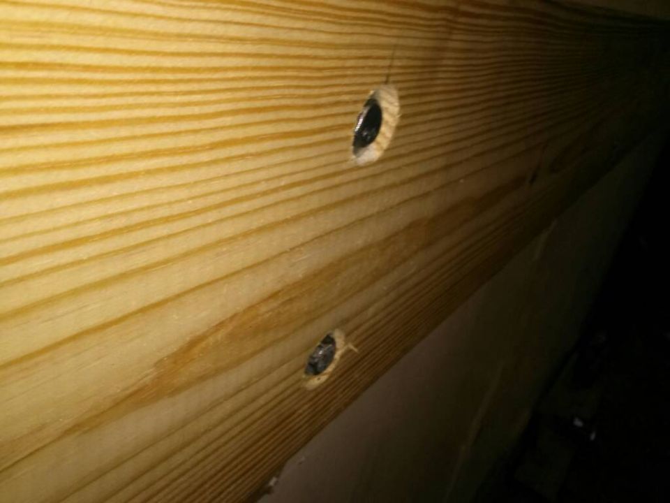 Wooden beams with two visible bolts and a Supermotors watermark