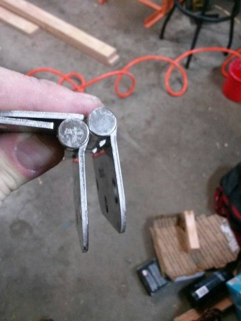 1996 Ford Bronco - Metal hinges are shown in detail, held by a person's fingers.
