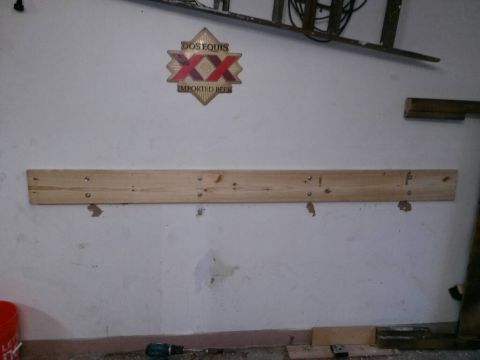 1996 Ford Bronco - A workbench is mounted on a wall above a Dos Equis sign in what appears to be a garage or workshop.