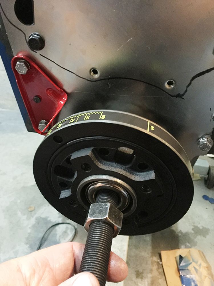 Crankshaft pulley with timing marks and a bolt being threaded in